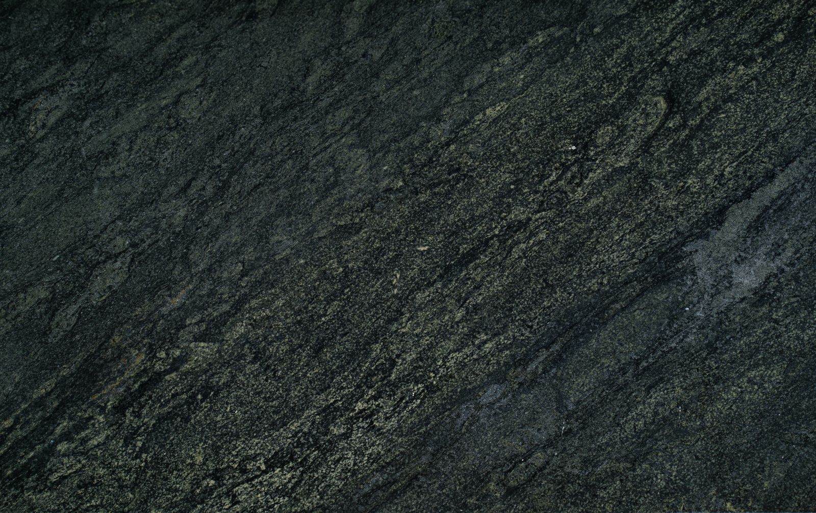 Dark granite slab surface showing dense natural crystal patterning
