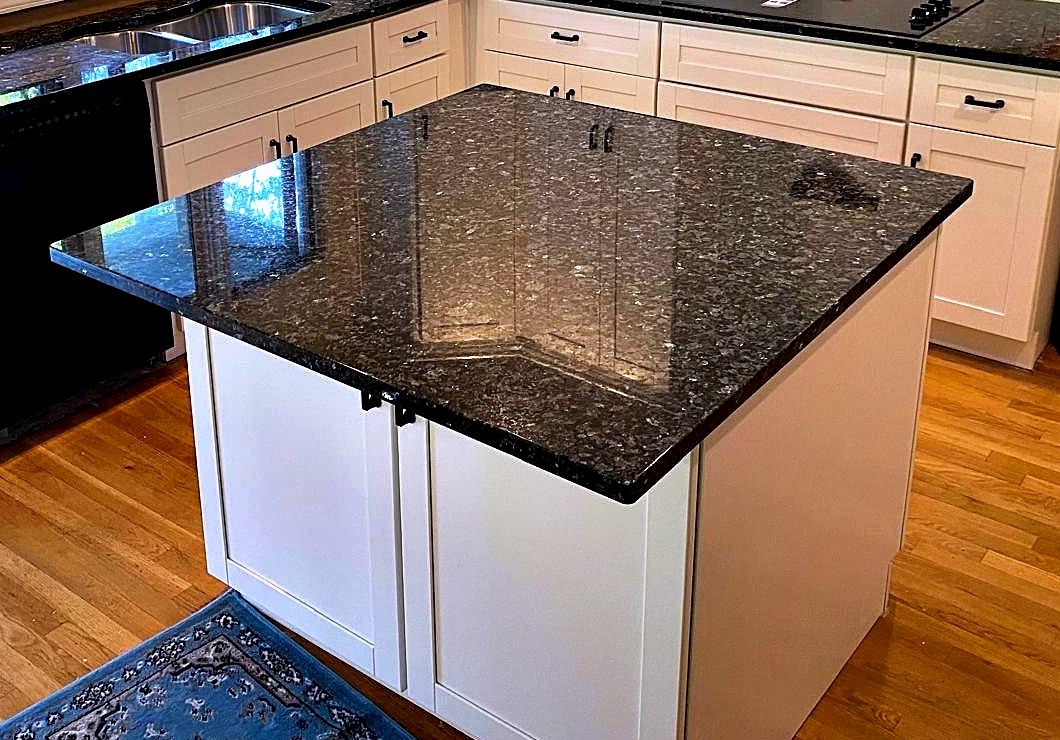 Speckled granite kitchen countertop with white cabinets