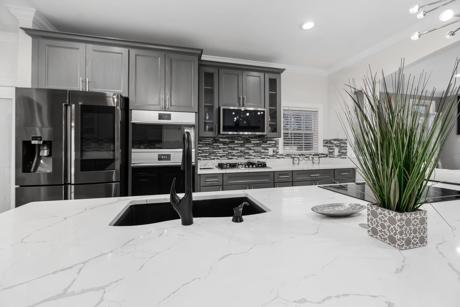 White quartz kitchen countertops and island with matte black fixtures